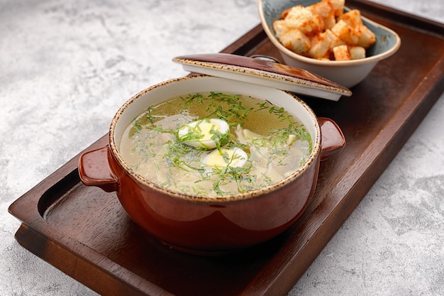 Caldo de galinha com ovos e biscoitos em uma placa de madeira