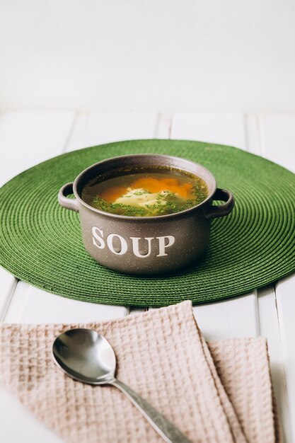 Caldo de legumes com brócolis, cenoura e ervas. Moldura vertical