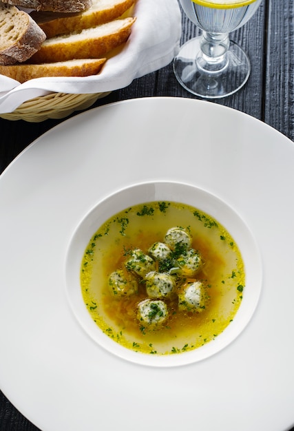 Caldo de sopa com almôndegas em um prato branco. Conceito para um menu em um restaurante