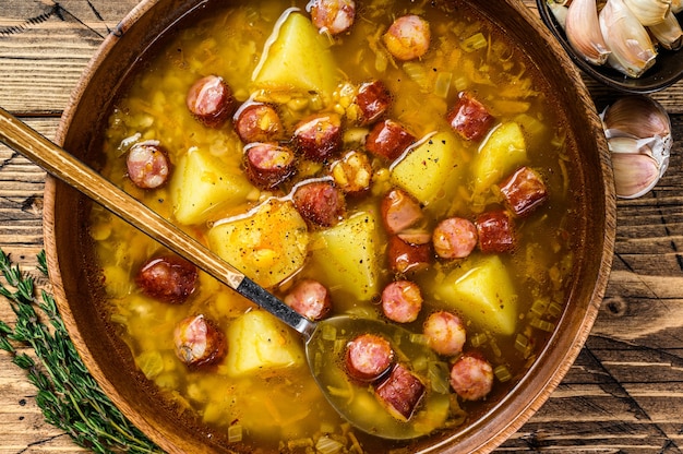 Caldo de sopa de ervilha com linguiça defumada em prato de madeira