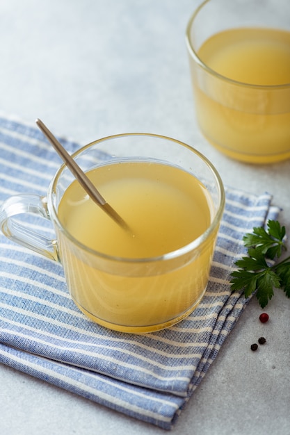 Caldo de huesos en un vaso sobre una mesa de luz, el enfoque selectivo