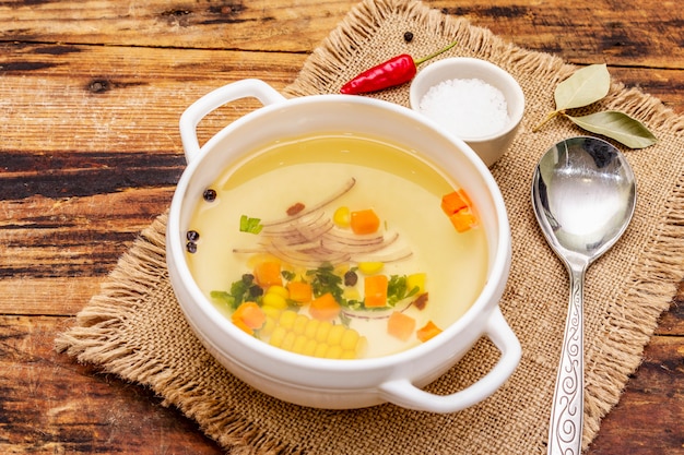 Caldo de pato transparente en un tazón con verduras. Caldo tradicional, comida saludable.