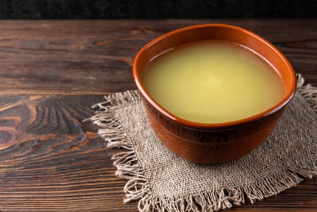 Caldo de pollo sobre fondo de madera