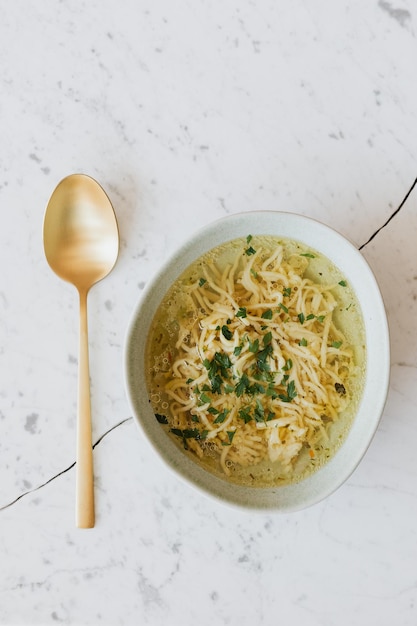 Foto caldo - sopa de pollo con fideos en un bol.