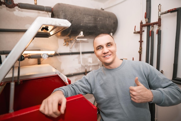 Calefacción de futuro sostenible Hombre usando horno de pellets Retrato de trabajador en la sala de calderas