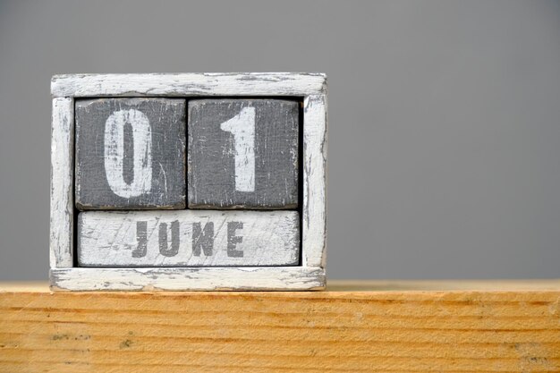 Calendario para el 01 de junio hecho de cubos de madera sobre fondo gris con un espacio vacío para el texto