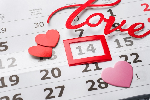 Foto calendario 14 de febrero. concepto del día de san valentín, corazones rojos y amor de la palabra.