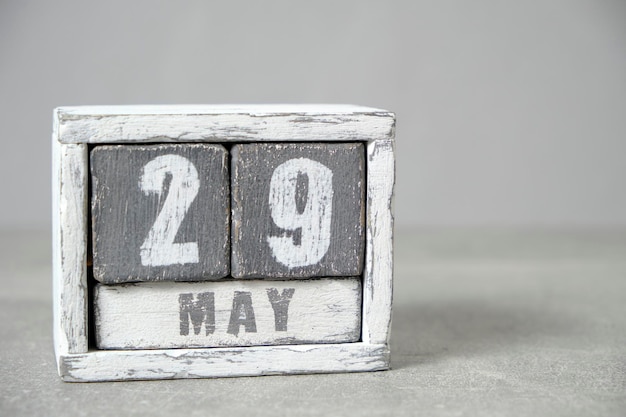Calendario del 29 de mayo hecho con cubos de madera de fondo gris con un espacio vacío para el texto