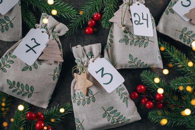 Calendario de adviento navideño para niños. Bolsos ecológicos de tela con regalos para niños. Navidad cero residuos. Concepto de bricolaje, regalos artesanales.