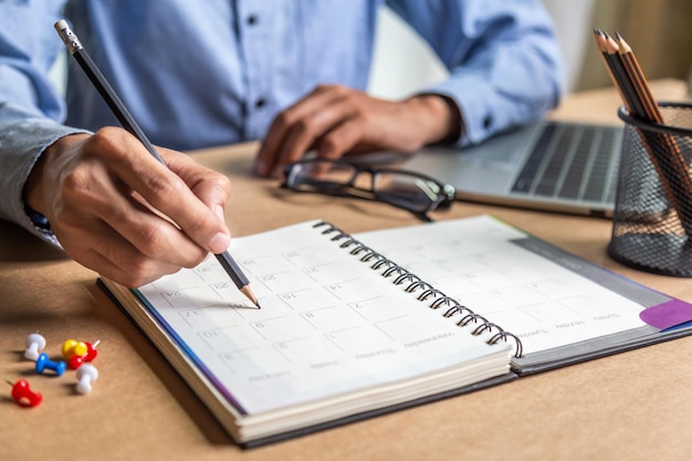 El calendario de la agenda del empresario y la agenda de recordatorios funcionan en línea en el hogar, los hombres planean diariamente