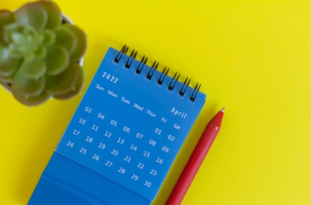 Calendario azul de escritorio para abril de 2022 para planificar sobre un fondo amarillo