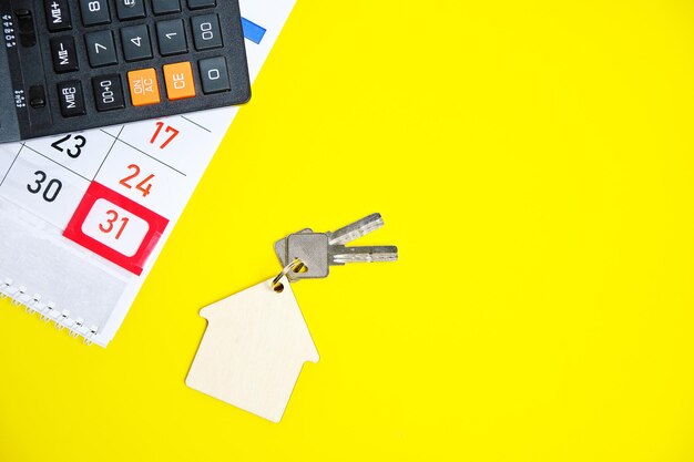 Calendario Calculadora de fin de mes Teclas de una casa o apartamento en un concepto de fondo amarillo Comprar un apartamento Casa Regalo de año nuevo