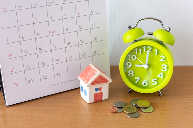 Calendario y casa en la mesa. Día de compra o venta de una casa o pago de alquiler o préstamo.