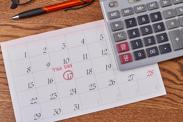 Calendário com dia fiscal marcado e caneta com calculadora