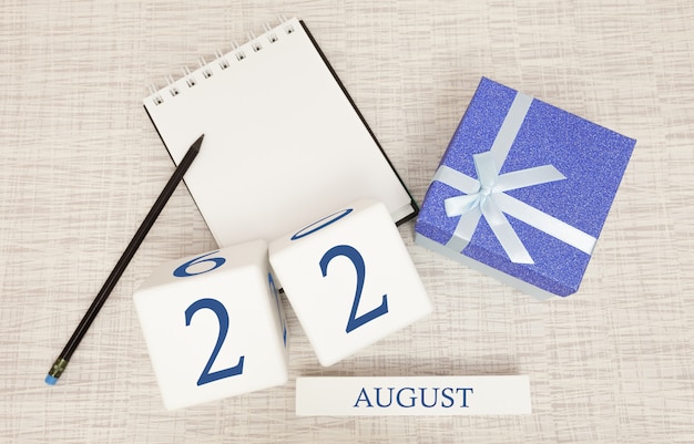 Calendário com texto azul na moda e números para 22 de agosto e um presente em uma caixa.