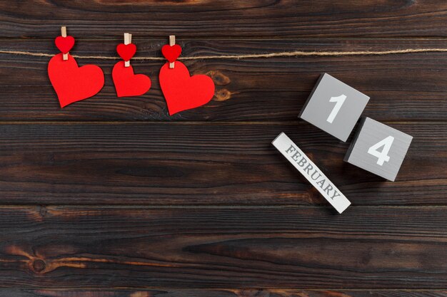 Calendario cubo con corazones rojos en mesa de madera