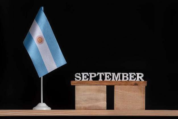 Calendário de madeira de setembro com bandeira argentina em fundo preto Feriados da Argentina em setembro