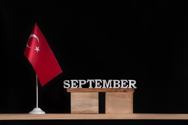 Calendário de madeira de setembro com bandeira turca em fundo preto. Férias da Turquia em setembro.