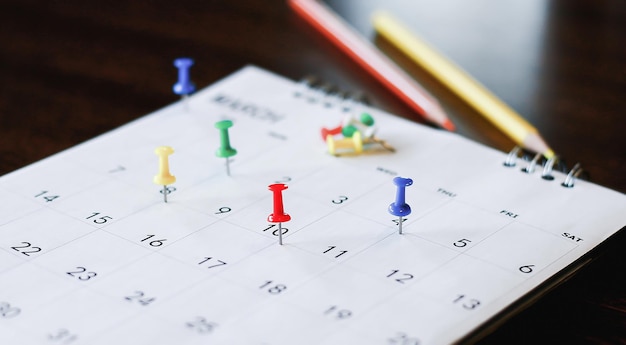 Calendário de mesa branco no conceito de planejamento de mesa de madeira escura