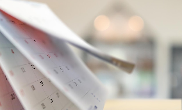 calendário de mesa de papel branco com fundo desfocado bokeh, compromisso e conceito de reunião de negócios