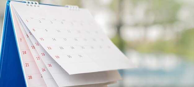 Calendário de mesa de papel branco com nomeação de fundo bokeh turva e conceito de reunião de negócios