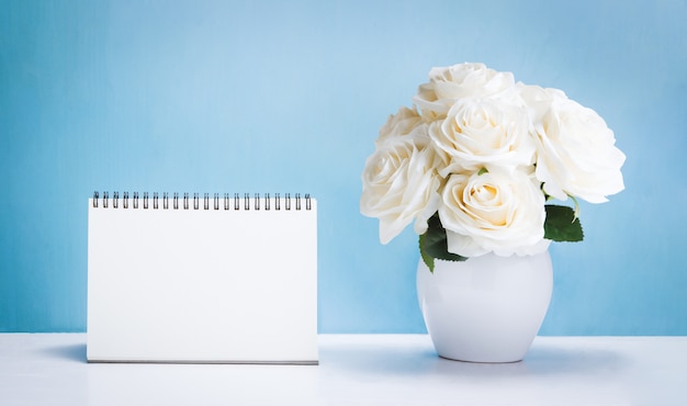 Foto calendário de mesa em branco com flores rosas brancas