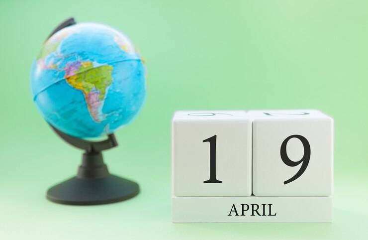 Foto calendário de primavera 19 de abril. parte de um conjunto sobre fundo verde turva e globo.