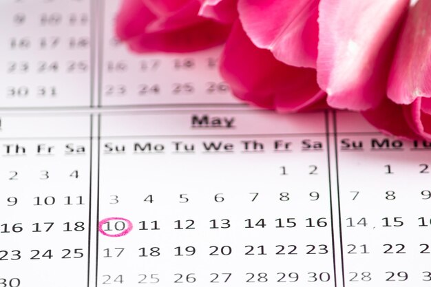 Foto calendario del día de la madre con una fecha marcada sobre un fondo de flores rosas un recordatorio de la fiesta