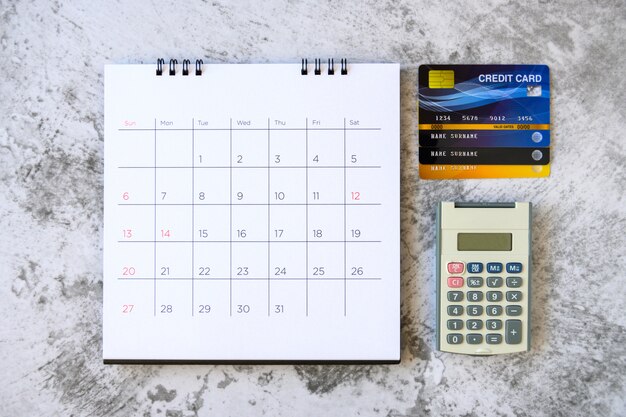 Calendario con días y tarjeta de crédito en la mesa. concepto de compra