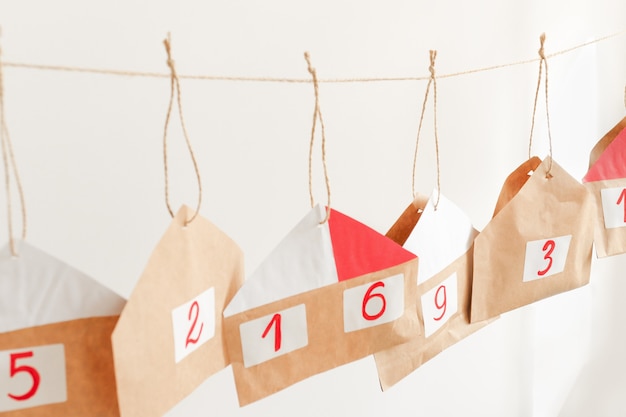 Calendário do advento com sacolas de presente penduradas dentro de casa. Decoração festiva feita à mão para o Natal