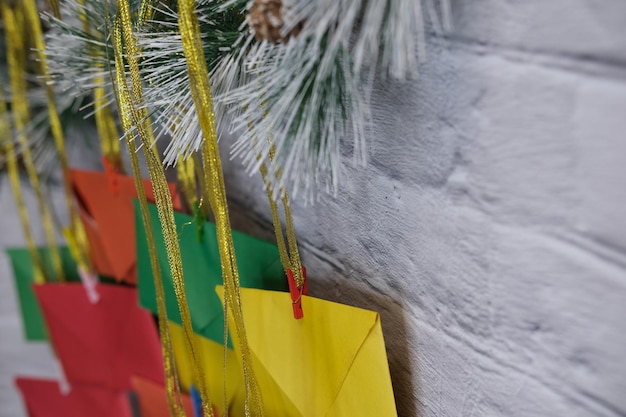 Foto calendário do advento em um fundo de uma parede de tijolos. envelopes multicoloridos feitos à mão.