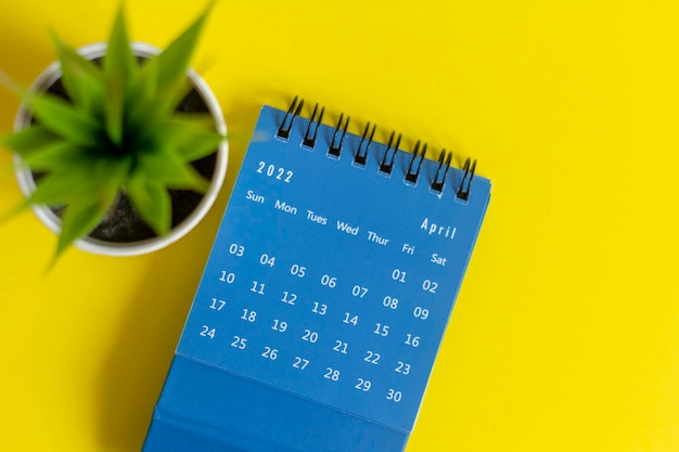 Calendario de escritorio para abril de 2022 sobre un fondo amarillo