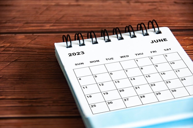 Calendario de escritorio blanco de junio de 2023 sobre fondo de mesa de madera Concepto de calendario y espacio de copia