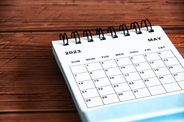 Calendario de escritorio blanco de mayo de 2023 sobre fondo de mesa de madera Concepto de calendario y espacio de copia