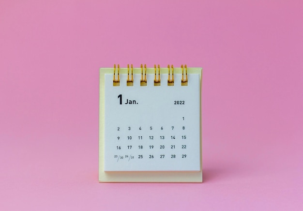 Calendario de escritorio para enero de 2022 sobre un fondo rosa.