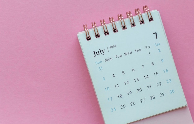 Calendario de escritorio para julio de 2022 sobre fondo rosa con espacio para copiar.