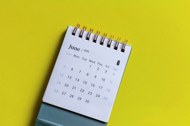 Calendario de escritorio para junio de 2022 sobre un fondo amarillo