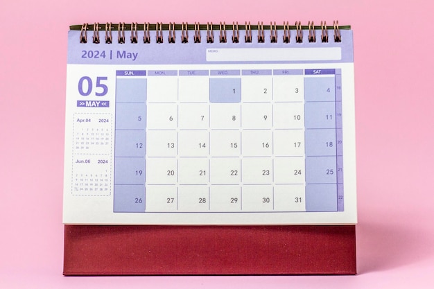 Calendario de escritorio para mayo de 2024 sobre un fondo rosa