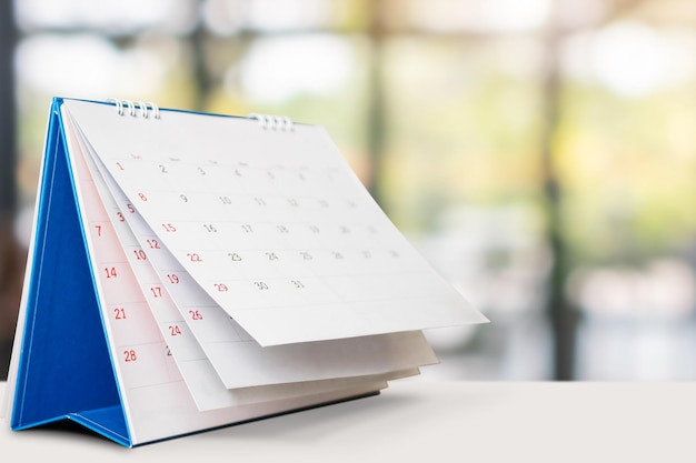 Calendario de escritorio en la mesa con cita de fondo bokeh borrosa y concepto de reunión de negocios