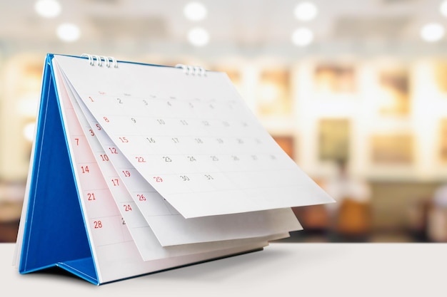 Calendario de escritorio en la mesa con cita de fondo bokeh borrosa y concepto de reunión de negocios