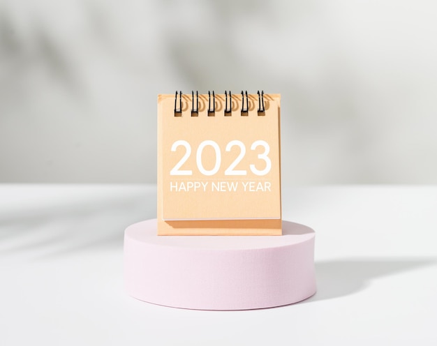 Calendário feliz ano novo 2023 no pódio rosa com fundo branco