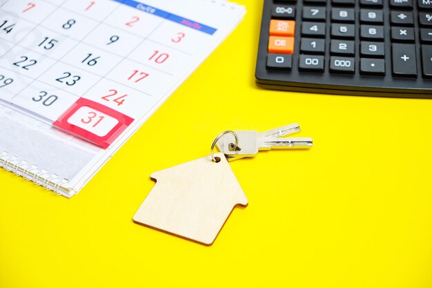 Calendario de fin de mes Calculadora Teclas para una casa o apartamento en un concepto de fondo amarillo Comprar una casa de apartamentos Regalo de año nuevo