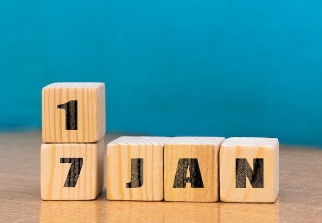 Calendario en forma de cubo para el 17 de enero sobre superficie de madera con espacio vacío para el calendario textcube para enero sobre fondo de madera