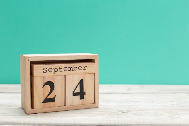 calendario en forma de cubo de madera para el 24 de septiembre sobre una mesa de madera