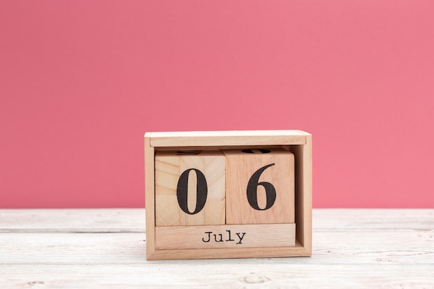 Foto calendario de forma de cubo de madera para el 6 de julio en la mesa de madera
