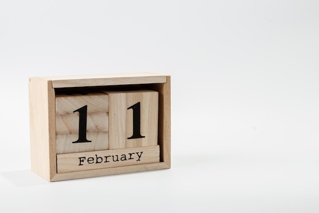 Calendario de madera 11 de febrero sobre un fondo blanco.