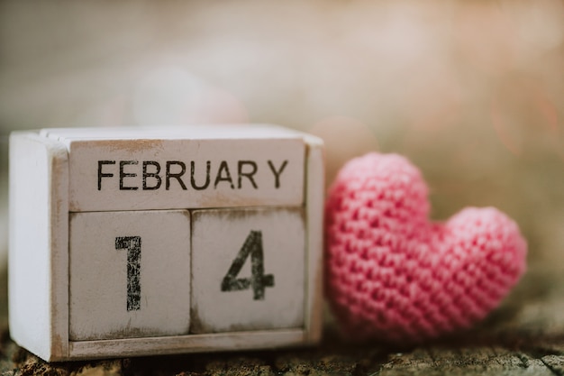 Calendario de madera del 14 de febrero con corazón rosa.