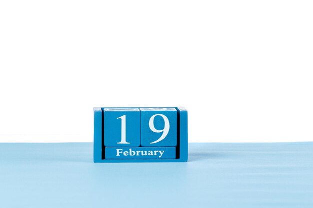 Calendario de madera 19 de febrero sobre un fondo blanco.