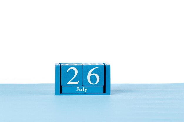 Calendario de madera el 26 de julio sobre un fondo blanco.