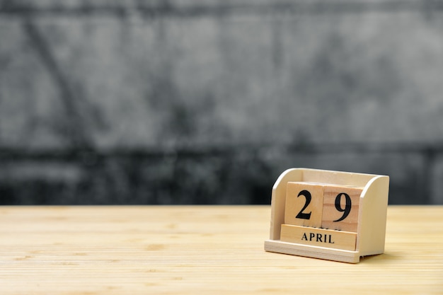 Calendario de madera del 29 de abril en el fondo abstracto de madera del vintage.